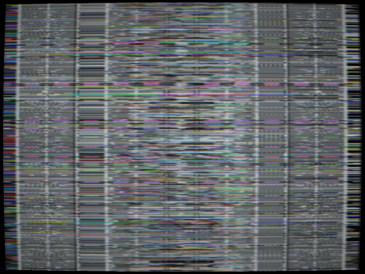 Nagravision (Canal+, 1989+) — PAL composite with full-field Fisher-Yates permutation of scan lines. Every pixel within each line is completely untouched — luma bandwidth, chroma saturation, scanline sharpness and CRT structure are all preserved. Only the vertical position of each line is scrambled. The BBC Test Card F is clearly recognisable: the circle, face, colour patches and border elements are all present with correct colour and sharpness, but at wrong vertical positions — fragments of the image distributed across the frame.
