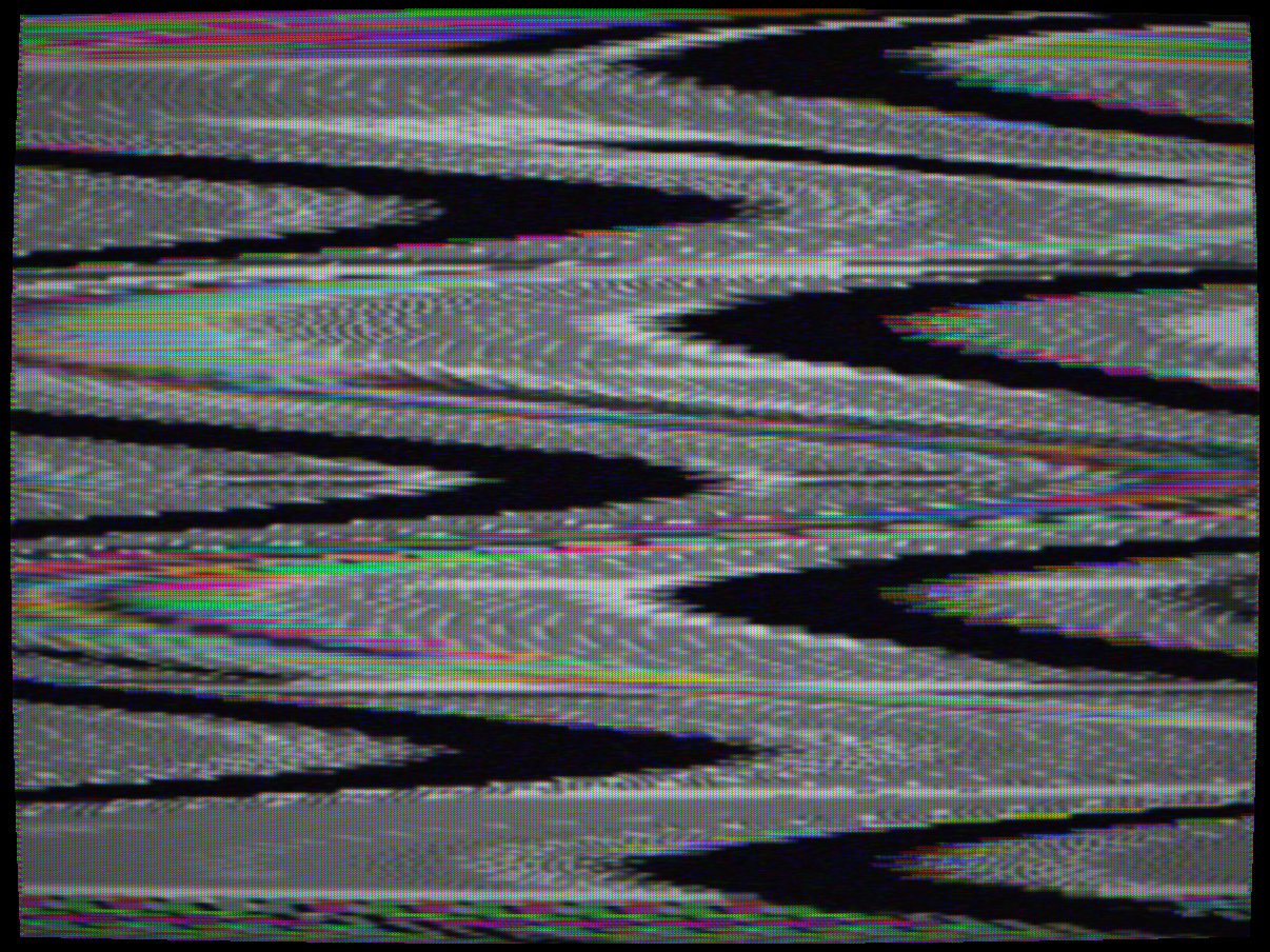 SSAVI/Z-TAC scrambling (US cable 1982–1988) — PAL composite showing the characteristic sinusoidal S-curve tearing produced when raised sync tips cause the H-oscillator to hunt rather than free-run. The picture content sweeps left and right in smooth sinusoidal waves of approximately 3–4 complete cycles per frame height, with colour fringing at the displacement extremes. The entire field is simultaneously colour-negative inverted — whites become black, colours shift to their complements — giving the combined effect of a smoothly-undulating colour-negative image unique to SSAVI.